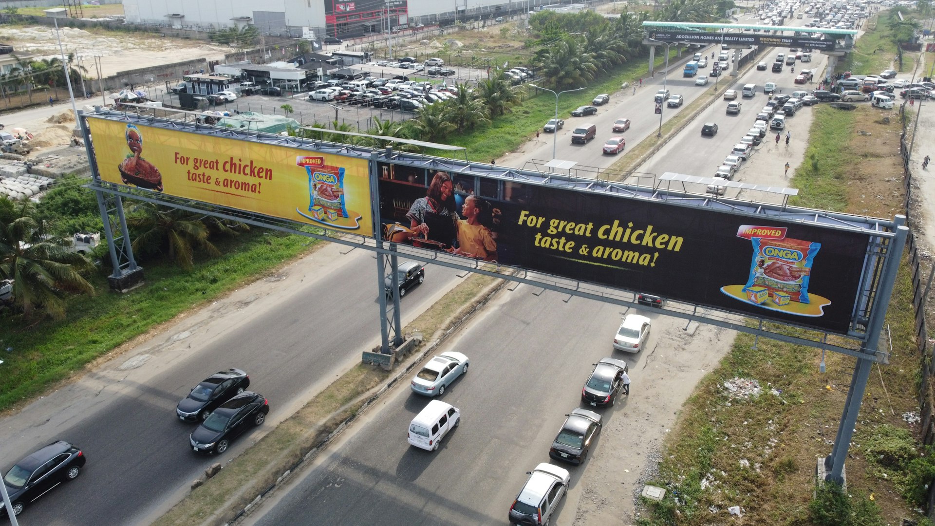 Billboard advertisements are seen over a busy highway.